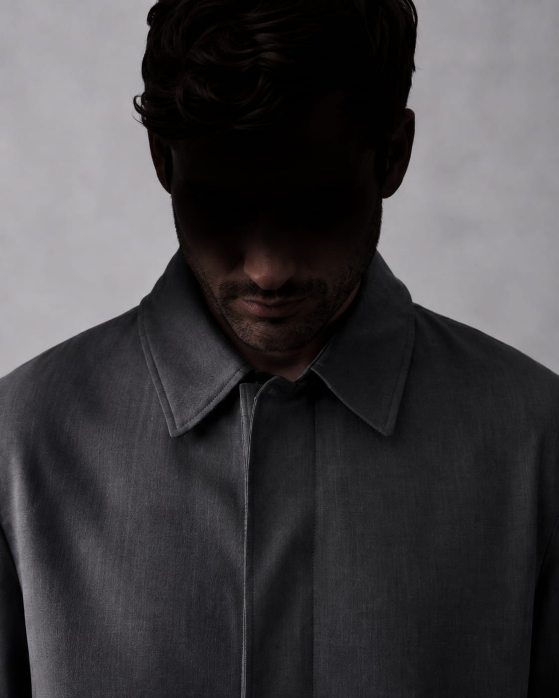 The No Trace Jacket close up, collar flat, the wearer's face lost in shadow