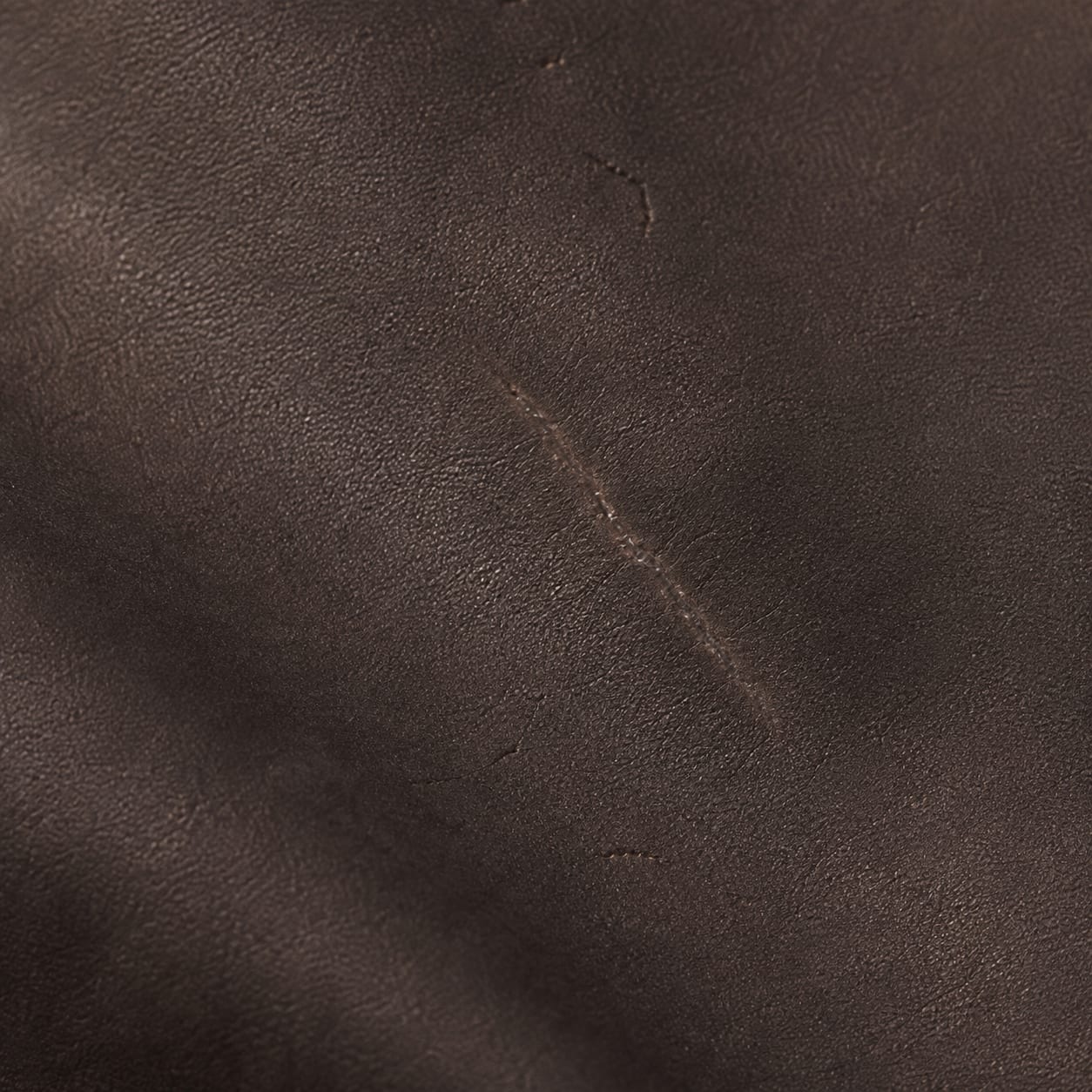 Macro of the fabric with one sealed cut, a faint raised scar line